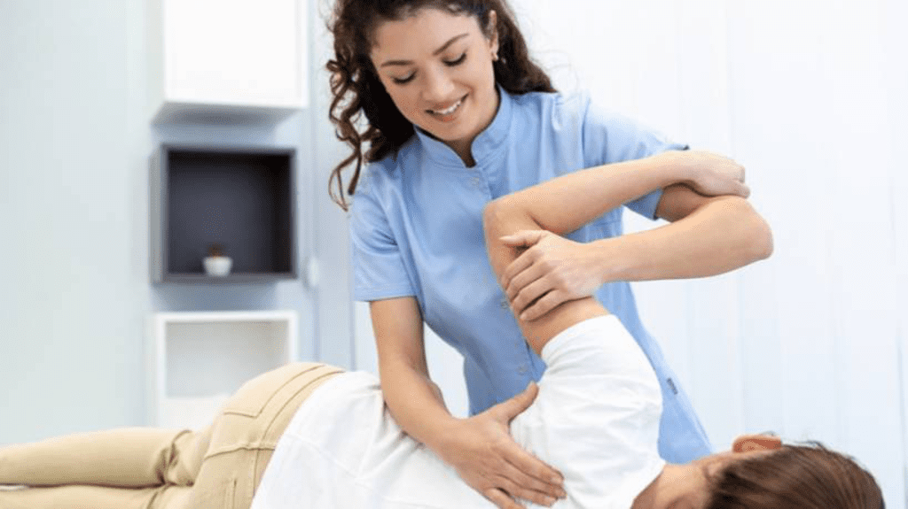 Eine Chiropraktikerin behandelt ihre Patientin mit geübten Griffen auf einer Liege. 