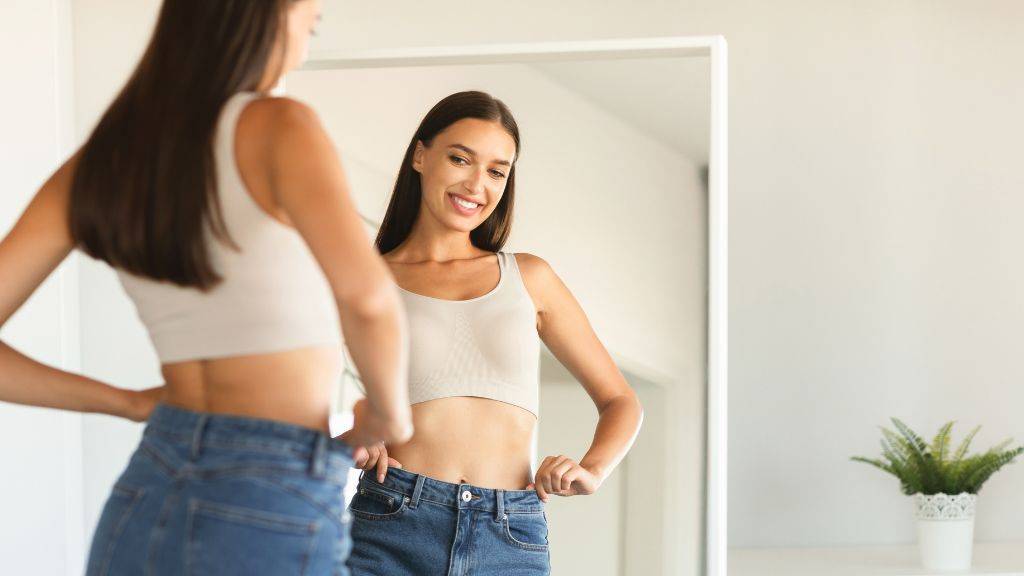 Ein junges Mädchen betrachtet sich zufrieden im Spiegel.