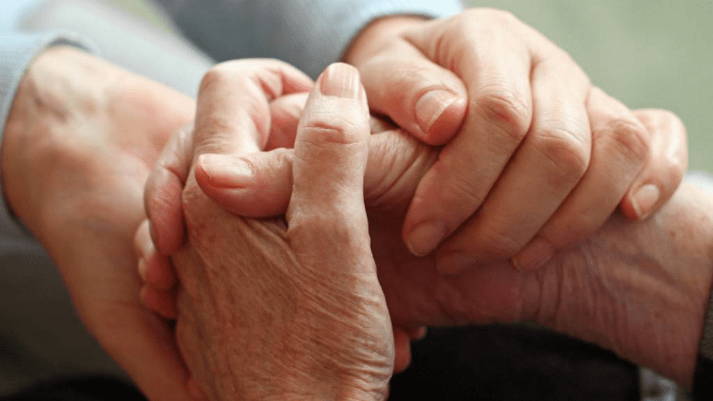 Zwei Menschen halten sich liebevoll an den Händen – Symbol für Fürsorge, Nähe und Unterstützung im Pflegealltag zwischen pflegebedürftigen Personen und Angehörigen.